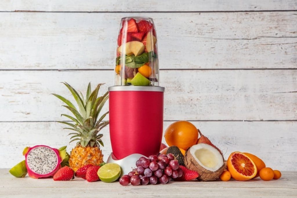red nutri bullet style fast blender with fruit